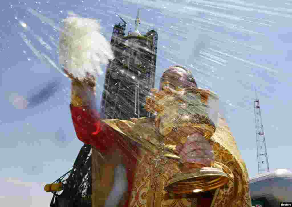 An Orthodox priest conducts a blessing in front of the Soyuz TMA-13M spacecraft set on the launch pad at Baikonur cosmodrome in Kazakhstan. (Reuters/Shamil Zhumatov)