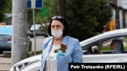 Женщина в защитной маске идет по улице. Алматы, 9 мая 2020 года.