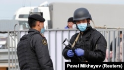 Казахстанские военные стоят у контрольно-пропускного пункта при въезде в Алматы. 24 марта 2020 года.