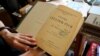 UKRAINE – The girl holds an exhibit in the museum, the fourth volume (1903) of the original edition of the ten-volume monograph "History of Ukraine-Rus" in the State Memorial Museum of Mikhail Hrushevsky. Lviv, August 16, 2017