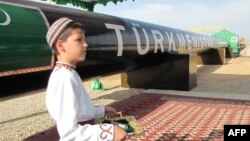 Туркменский мальчик в национальном костюме ждёт президента на официальной церемонии запуска трубопровода в Шатлике. 31 мая 2010 года