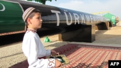 A Turkmen boy in traditional dress waits for the president at an official launch ceremony for the East-West gas trunk pipeline in Shatlyk in May 2010.