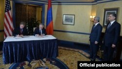 U.S. Assistant Trade Representative Daniel Mullaney (left) and Armenian Foreign Minister Edward Nalbandian sign a U.S.-Armenian Trade and Investment Framework Agreement in Washington on May 7. Armenian President (second right) was present for the signing. 