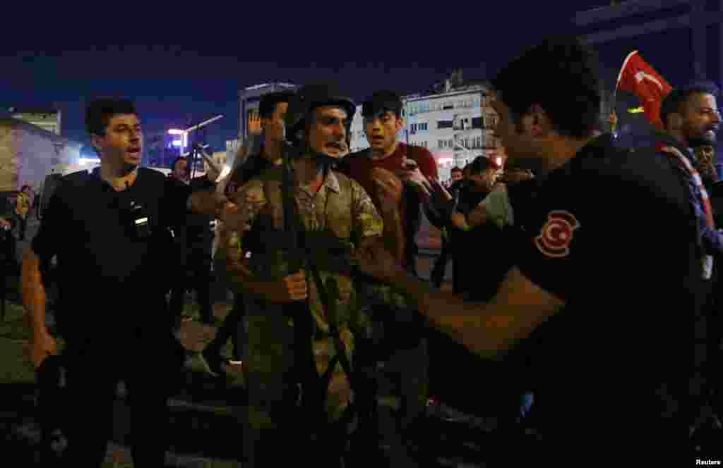 Turkish soldiers surrender their weapons to police on Taksim Square. A statement released by the military said the coup attempt was a response to &quot;rising autocratic rule... and increased terrorism.&quot;