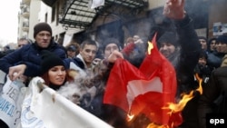Учасники акції протесту спалюють прапор Туреччини під її посольством у Москві. 25 листопада 2015 року