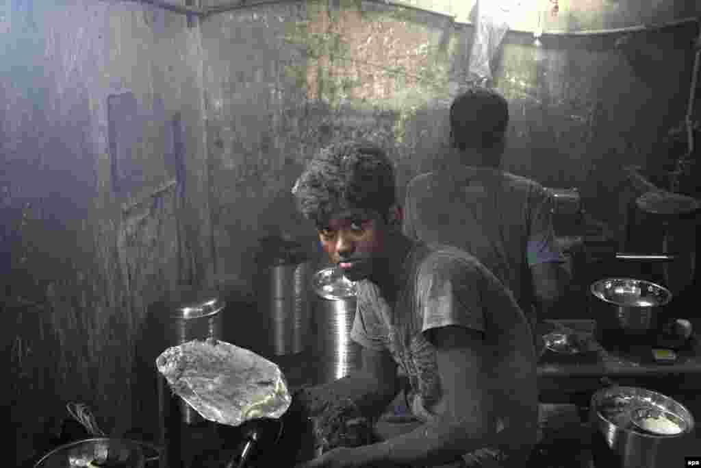 A Bangladeshi youth polishes a pot at an aluminium factory in Dhaka. (epa/Abir Abdullah)