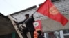 People fix national flags atop a local polling station in the Besh-Kungey village outside the Kyrgyz capital, Bishkek.