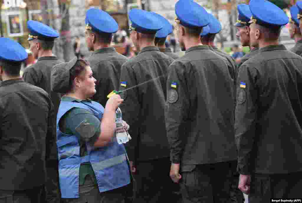 Украінская мэдсястра палівай вадой жаўнераў на рэпэтыцыі параду ў Кіеве, каб астудзіць іх падчас сьпёкі