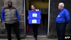  یک مامور رای‌گیری در حال انتقال صندوق‌های اخذ رای در آخرین ساعات پیش از آغاز همه‌پرسی در اسکاتلند