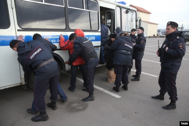 Policia duke i ndaluar disa migrantë, nën dyshimet se kanë punuar ilegalisht në një treg në Moskë. Fotografi e vitit 2013.