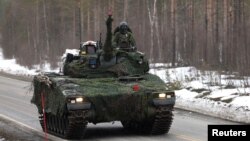 Un tanc al armatei suedeze la exercițiul militar „Cold Response 2022”, care a reunit aproximativ 30.000 de soldați din țările membre NATO, precum și din Finlanda și Suedia, în Setermoen, în Cercul Arctic, Norvegia, 25 martie 2022.