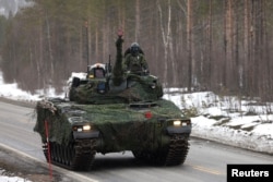 Swedish armored vehicles and tanks participate in a military exercise called Cold Response 2022, which gathered around 30,000 troops from NATO member countries, as well as Finland and Sweden, in the Arctic Circle in Norway on March 25.