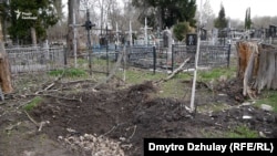 Воронка от мины на сельском кладбище, где российские военные убивали гражданских