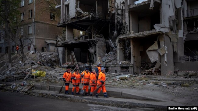 Clean-up crews prepare to work at the site of an explosion in Kyiv on April 29.