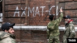 Мъже от чеченския батальон "Ахмат" рисуват графити с надпис "Ахмат е сила" в Мариупол, 17 април 2022 г.