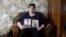 Viktoria Vovk holds portraits of her son and son-in-law. "They tormented our children. For what? They didn't hurt anyone!"