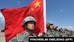 Китайский солдат держит флаг во время совместных военных учений Шанхайской организации сотрудничества (ШОС) «Мирная миссия — 2016» на полигоне «Эдельвейс» в Балыкчи, примерно в 200 километрах от Бишкека, 19 сентября 2016 года
