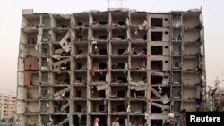 U.S. and Saudi investigators work into the night searching for clues outside the apartment building destroyed by a bomb at the Khobar Towers housing complex for U.S. military personnel in Dhahran, June 25, 1996