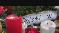 Квіти та свічки біля посольства Польщі