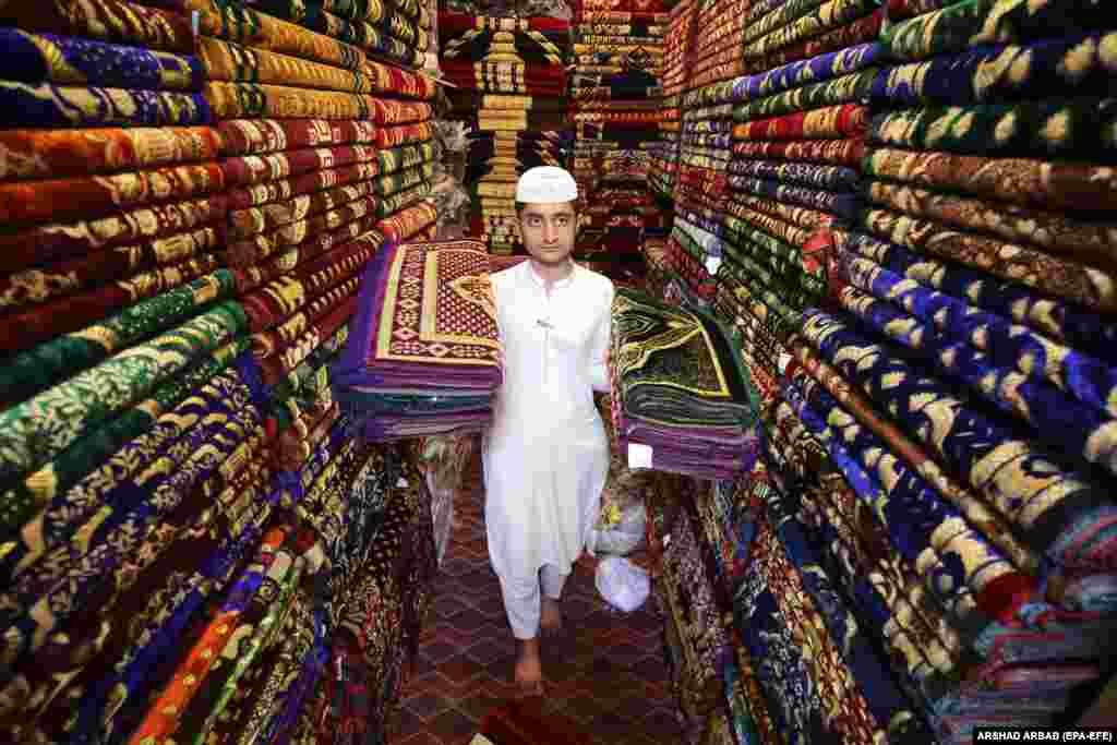 A vendor sells Muslim prayer mats at a shop in Peshawar, Pakistan. 