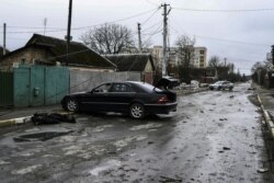 Cadavrul unui bărbat zace pe jos, pe o stradă din Bucea, 2 aprilie 2022.