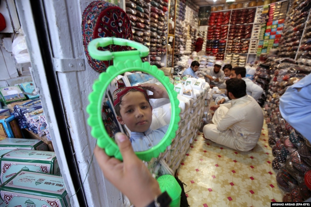 Një djalë i vogël pakistanez provon një kësulë të re myslimanësh para muajit të shenjtë të Ramazanit në Peshavar më 29 mars.