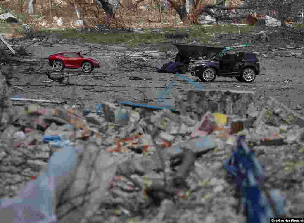 Játék autók hevernek elhagyatottan egy lerombolt ház udvarán március 29-én a kijevi frontvonalon