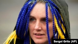 Az Ukrajnába visszatérő Natalia Naumova, hajában az ukrán nemzeti színekkel a lengyelországi Przemysl vasútállomásán március 30-án