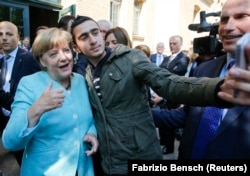 „Merkel-Merkel” a fost una din scandările refugiaților șicanați de autoritățile din Ungaria, Serbia și alte țări când încercau, în 2015, să ajungă în vestul Europei. În imagine: un migrant își face selfie cu cancelara germană la Berlin.