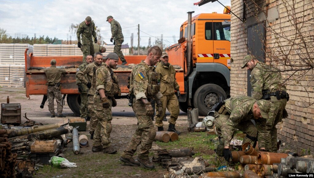 Garrett (center) and members of the Ukrainian police’s EOD unit transport artillery shells to a truck in Bucha, north of Kyiv, on April 28.