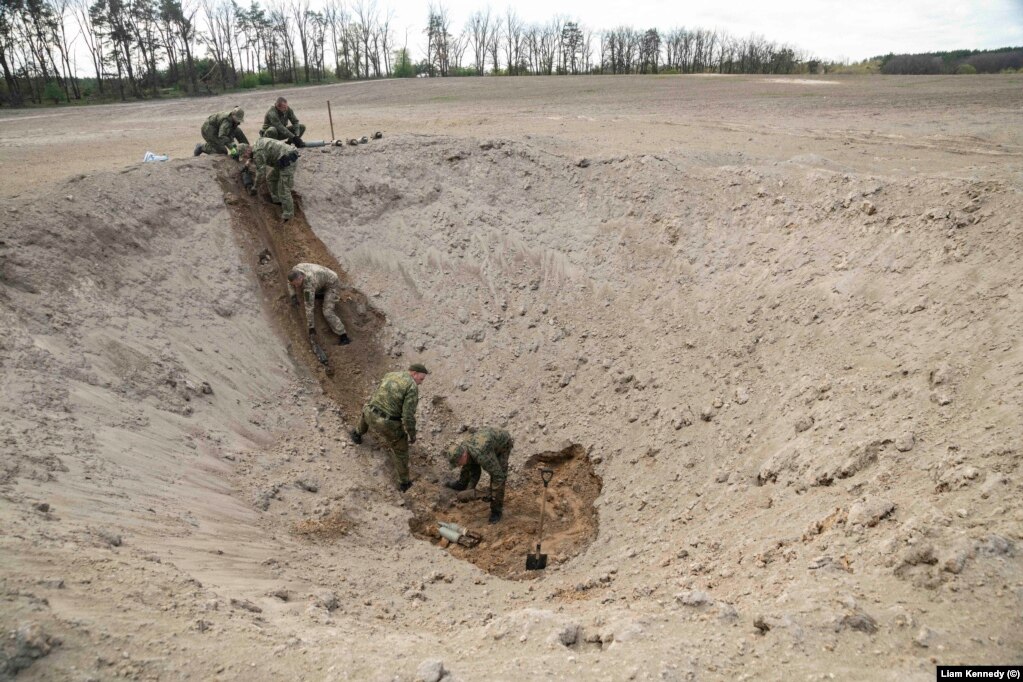 An EOD team working with Garrett prepares to destroy artillery shells north of Kyiv on April 28.