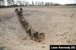 An EOD team working with Garrett prepares to destroy artillery shells north of Kyiv on April 28.