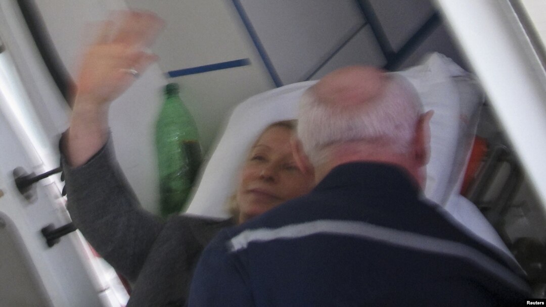 Yulia Tymoshenko waves from a stretcher as she is transported to an ambulance in Kharkiv on April 22.