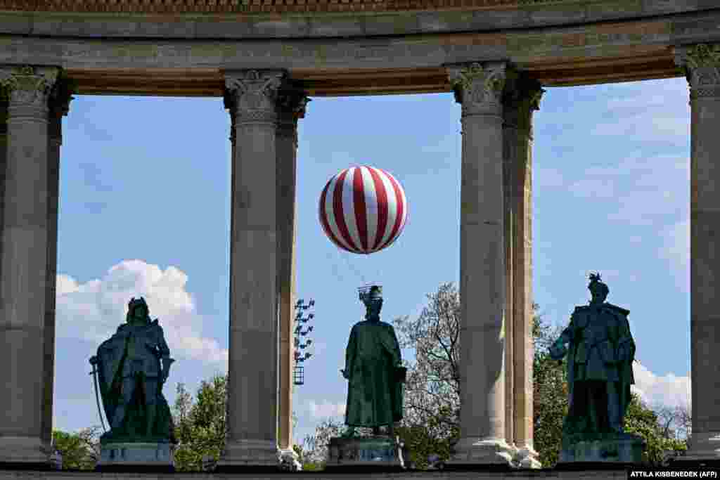 A large helium balloon is seen in the air behind statues of Hungarian kings near Heroes&#39; Square in Budapest.&nbsp;