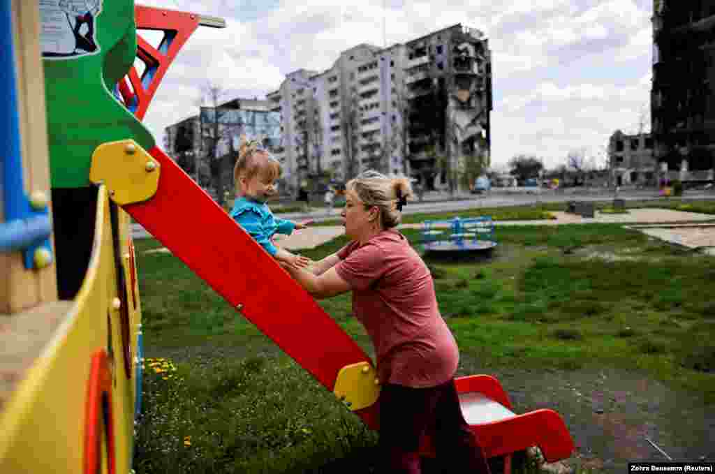 Një grua në Borodjanka të Ukrainës duke luajtur me vajzën e saj përpara një ndërtese të shkatërruar nga granatimet ruse.