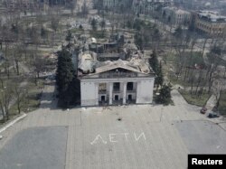 Пред уништениот театар во Мариупол со големи бели букви беше напишано „деца“ на руски јазик, април 2022 година.