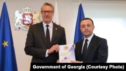 საქართველოს პრემიერ-მინისტრმა ირაკლი ღარიბაშვილმა (მარჯვნივ) ევროკავშირის ელჩს კარლ ჰარცელს ევროკავშირის კითხვარის პასუხები გადასცა. თბილისი, 2 მაისი, 2022 წ.