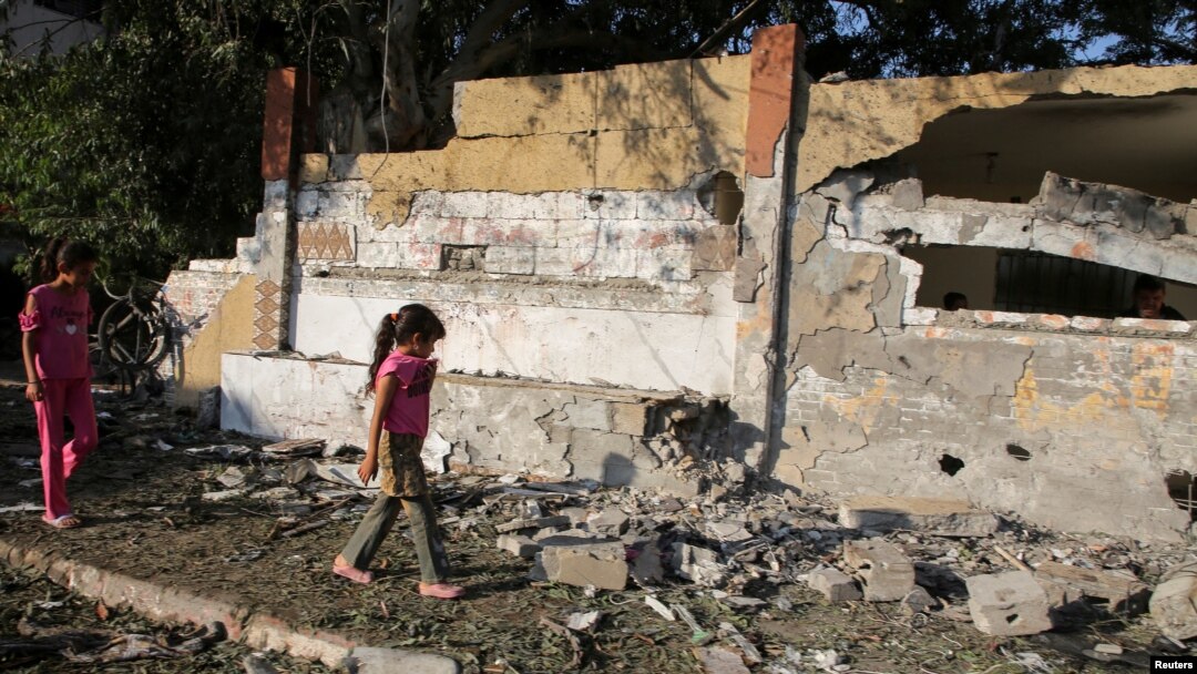 Fete din Khan Younis, la locul unei lovituri israeliene, în fața unei școli care adăpostește persoane strămutate. 10 iulie 2024.
