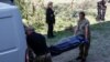 Medicii legiști urcă într-o ambulanță cadavrul unei fete ucise în timpul unui atac cu rachete rusești.