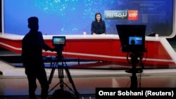 A female anchor reads the news at Tolo News studio in Kabul.