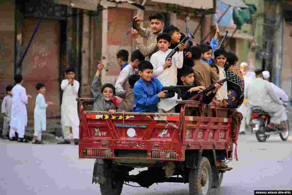 Pakistani children play with toy guns during Eid al-Fitr celebrations in Peshawar on May 2.&nbsp;