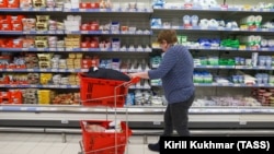 Russia - A customer shops for dairy at an Auchan hypermarket in Novosibirsk, April 7, 2022.