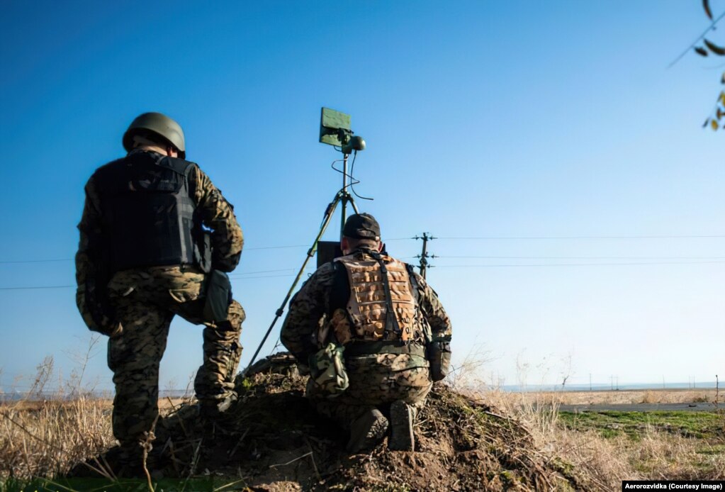 Ushtarë ukrainas stërviten për përdorimin e dronëve para pushtimit rus të vitit 2022. Ata shohin një ekran që tregon video në kohë reale nga një oktokopter, ndërsa një transmetues i montuar në trekëmbësh komunikon me dronin.