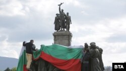 Протестиращите успяха да опаковат за кратко една от композициите на паметника с българското знаме.