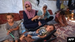 Micul palestinian Abdel Rahman Abu al-Jedian, care a contactat poliomielită în urmă cu o lună, doarme înconjurat de familie într-o tabără de refugiați. 27 august 2024.