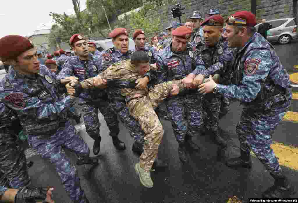 A man in military clothing grapples with police in Yerevan on May 2. Yerevan residents that RFE/RL&#39;s Armenian Service spoke to on May 3 expressed mixed feelings about the unrest, with one saying, &quot;In democratic countries, governments are formed through elections.&nbsp;Period.&quot;