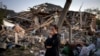 Жінка біля зруйнованого внаслідок російського бомбардування будинку, Київщина