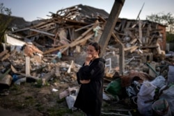 Жительница города Ирпень Киевской области около своего дома, разрушенного во время боевых действий, 3 мая 2022 года