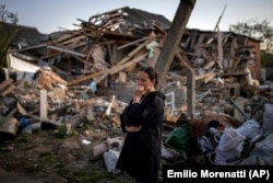 Ana Șevcenko, în vârstă de 35 de ani, aflată lângă casa sa distrusă de bombardamentele rusești, 3 mai 2022.