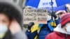 "Наслаждайтесь российским газом с запахом украинской крови" – плакат в руках участницы демонстрации в поддержку Украины в Германии